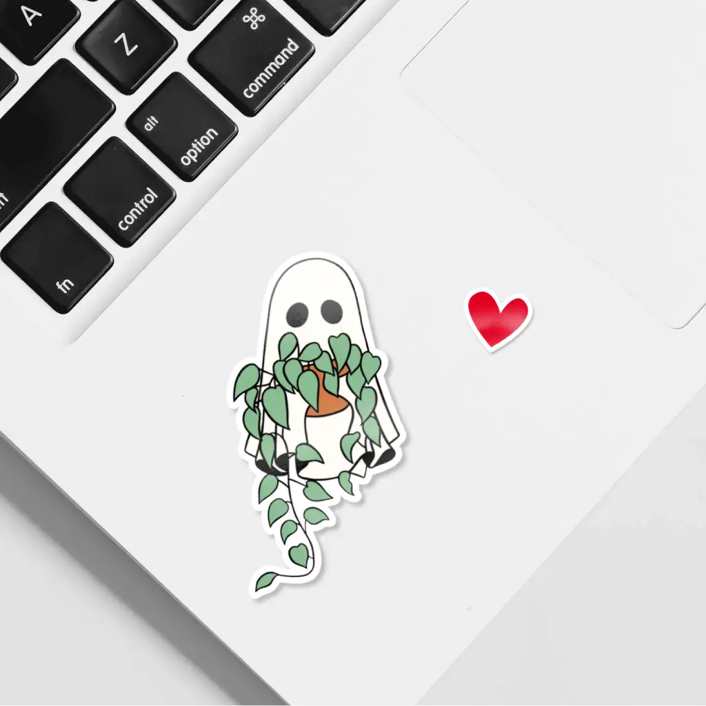 Pegatina de un fantasma abrazando una maceta con un Potos de hojas verdes. Ideal para decorar diarios, laptops y más.