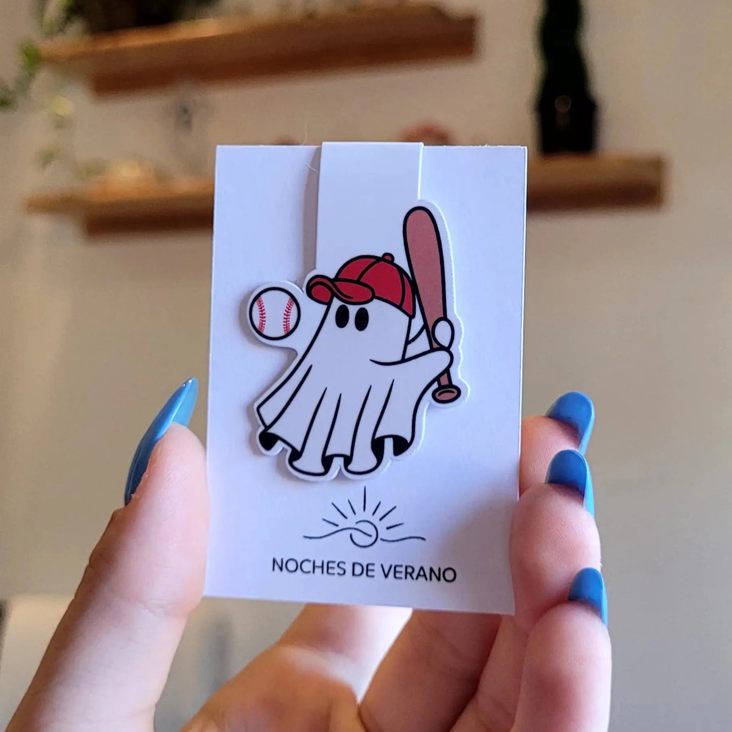 Marcapáginas magnético con diseño divertido de fantasma jugando al béisbol con un bate, perfecto para lectores que busquen un marcador de libros único y original de deporte.