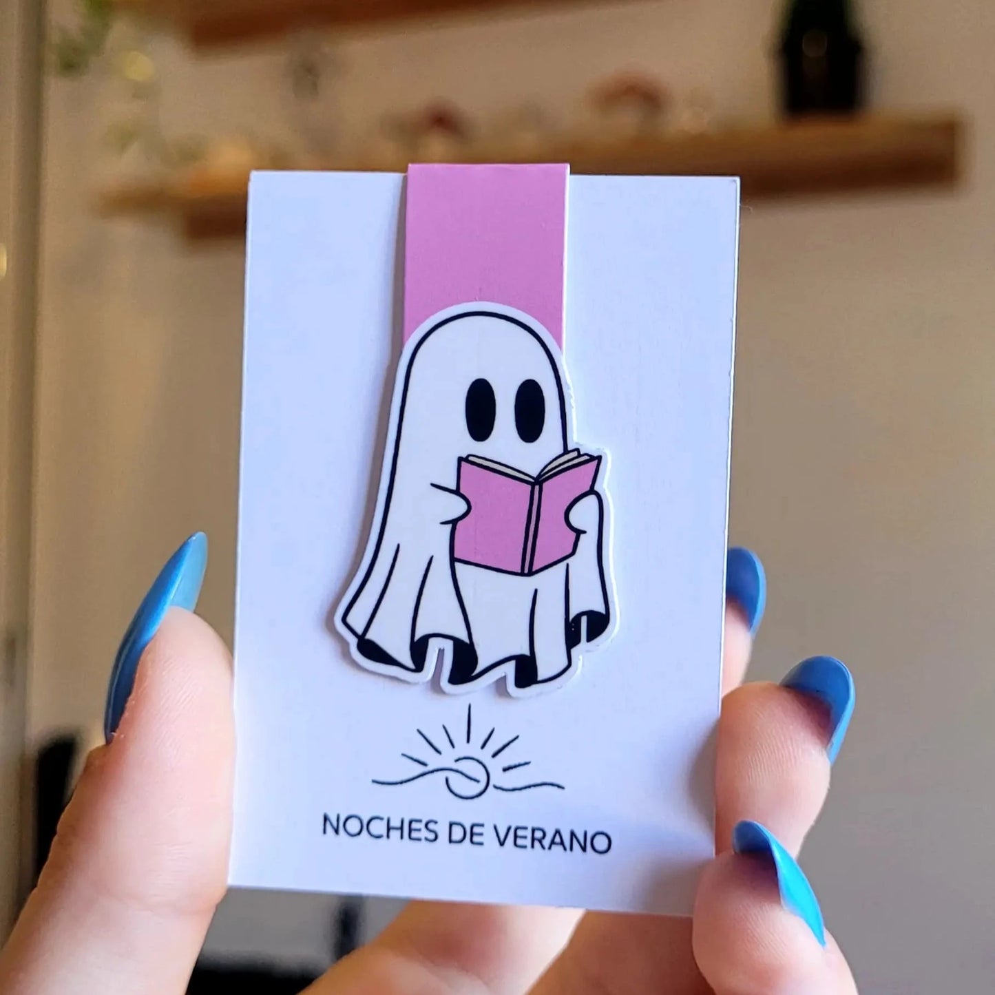 Marcapáginas magnético con diseño divertido de fantasma leyendo un libro rosa, perfecto para lectores que quieran un marcador de libros original.