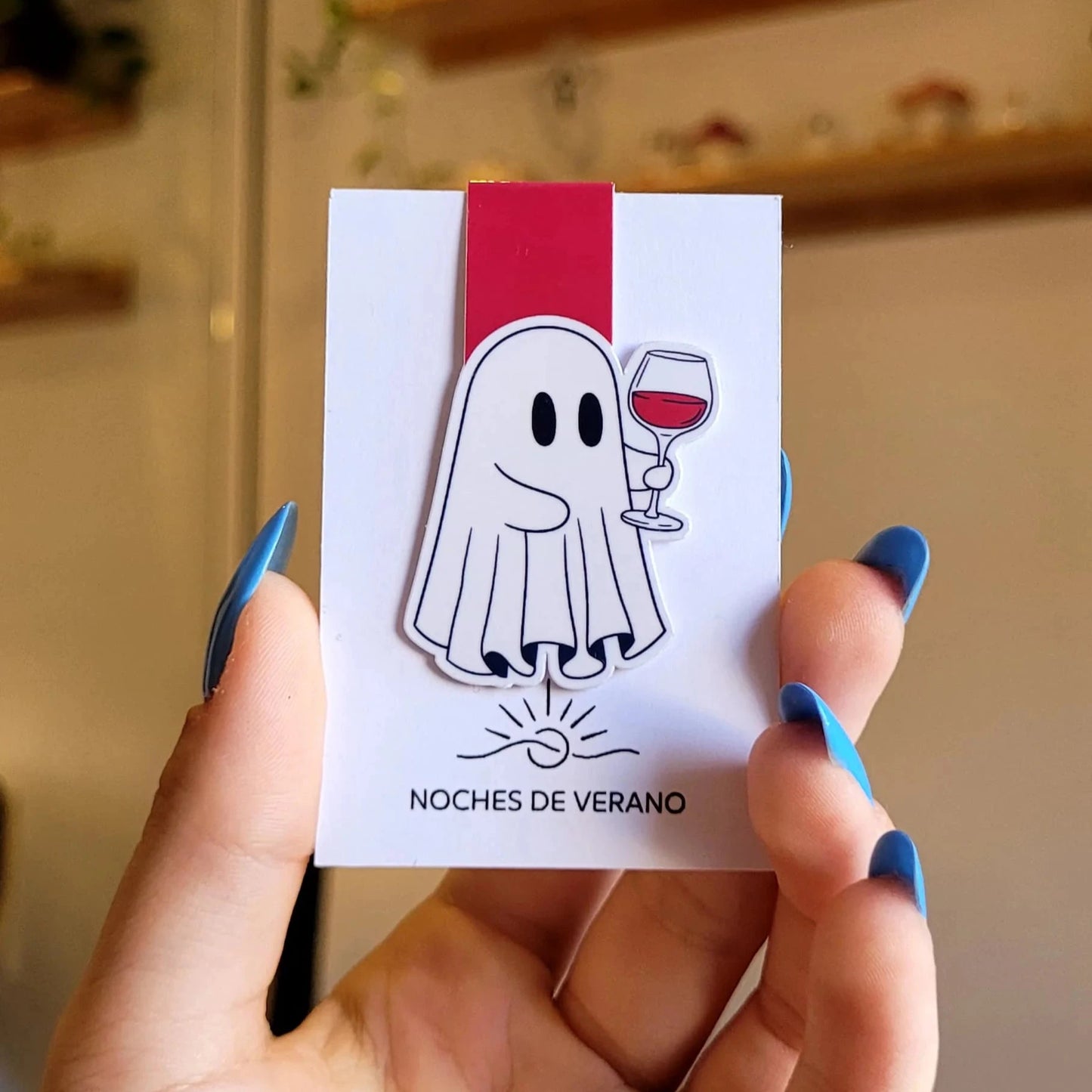 Marcapáginas magnético con diseño divertido de fantasma bebiendo una copa de vino tinto, perfecto para lectores que quieran un marcador de libros original.