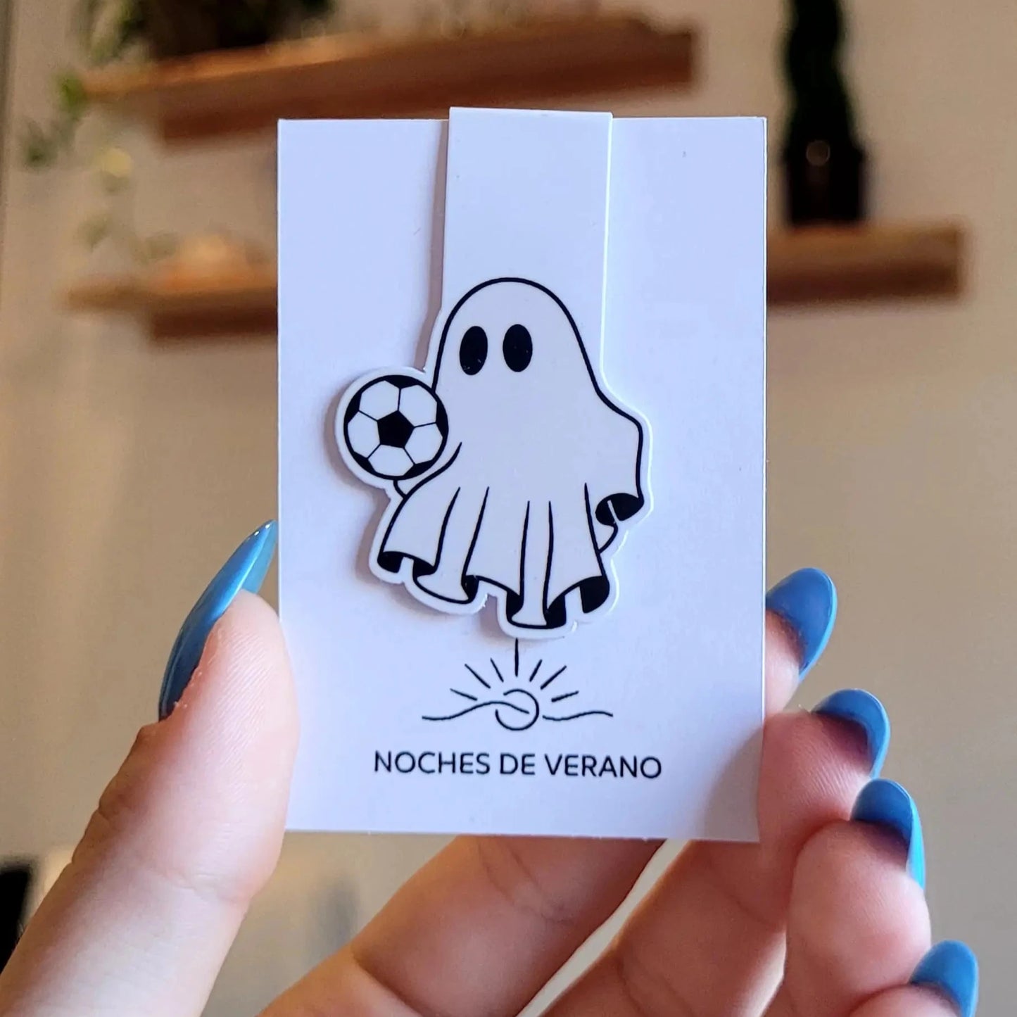 Marcapáginas magnético con diseño divertido de fantasma jugando al fútbol con un balón, perfecto para lectores que busquen un marcador de libros único y original de deportes.